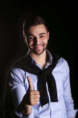 Başparmak yukarıya ile rahat genç işadamı