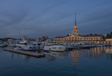 Krasnodar Bölgesi, Sochi 'deki deniz istasyonu binası. Karadeniz. Alacakaranlık. İskelede küçük tekne ve yatlar.