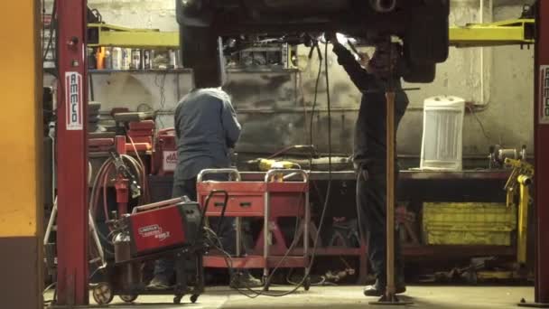 Soldadura en un coche en un garaje — Vídeos de Stock