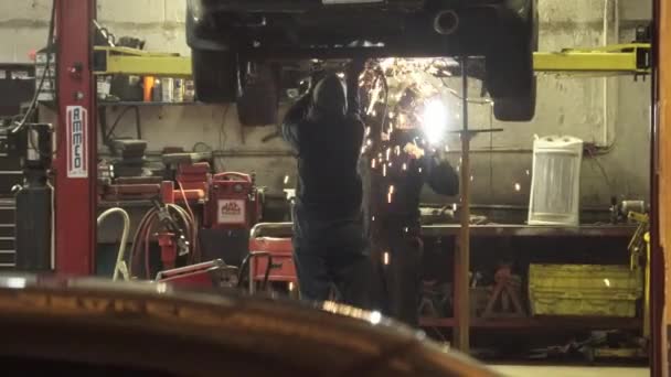 Soldagem em um carro em uma garagem — Vídeo de Stock