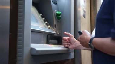 Bir Bancomat kullanan kişiler