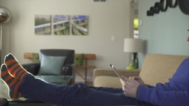Людина на дивані використовуючи новітні технології в 4K (3 з 9 ) — стокове відео