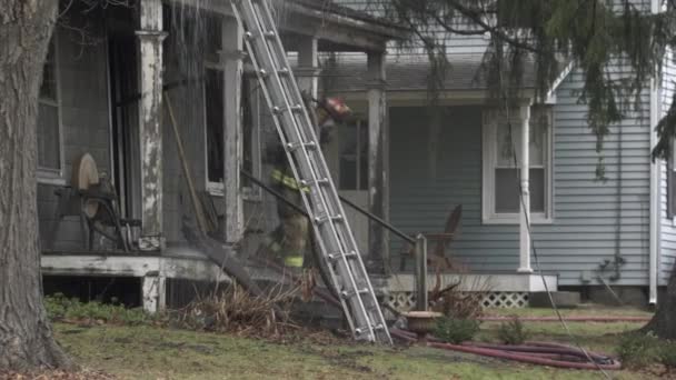 Brannmenn slukker et brennende hus – stockvideo