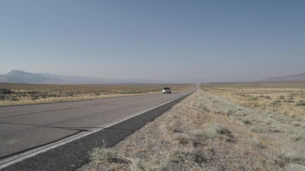 Auto rijdt langs een weg in de woestijn — Stockvideo