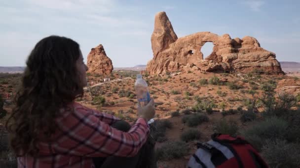 Crane Shot van een vrouw drinkwater in het Arches National Park — Stockvideo