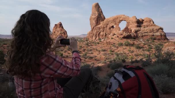 Crane Shot de una mujer tomando fotos en el Parque Nacional Arches — Vídeos de Stock