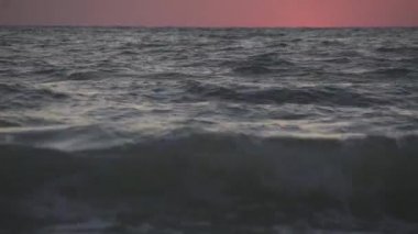 Dalgalar yavaşça plaj boyunca yıkama bir gün batımı görünümü