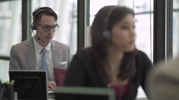 Escena de un servicio de atención al cliente o centro de llamadas — Vídeos de Stock