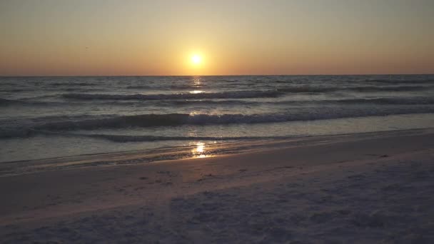 En solnedgång utsikt över vågorna försiktigt tvätta längs stranden — Stockvideo