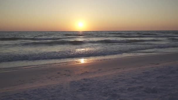 Une vue coucher de soleil des vagues se lavant doucement le long de la plage — Video
