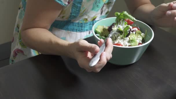 Una mujer disfruta de una ensalada sentada — Vídeo de stock