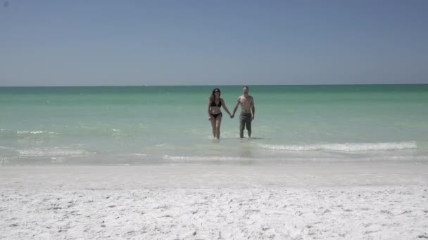 Um casal desfruta de uma praia romântica em um resort — Vídeo de Stock