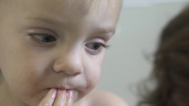 Ein Kind genießt einen Snack, während es am Esstisch sitzt — Stockvideo