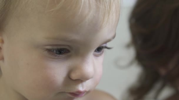 A child enjoys a snack while seated at the dinning room table — Stock Video