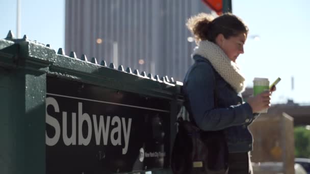 En vacker ung kvinna har en solig dag nära en tunnelbanestation — Stockvideo