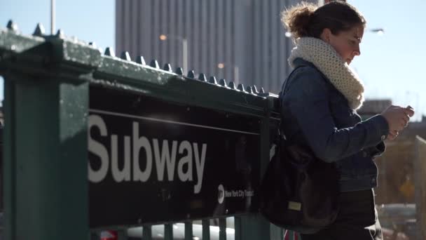 Egy gyönyörű fiatal nő élvezi egy napsütéses napon a metró állomás közelében — Stock videók