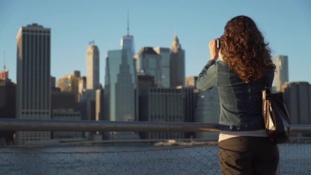 Uma mulher tira fotos do horizonte de Nova Iorque — Vídeo de Stock