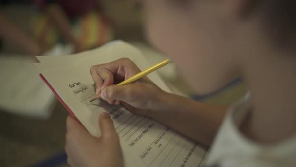 Studenten werken bij hun bureaus in een klaslokaal — Stockvideo