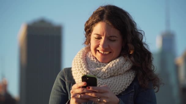 Een mooie vrouw maakt gebruik van haar mobiele telefoon om te bellen en tekst — Stockvideo