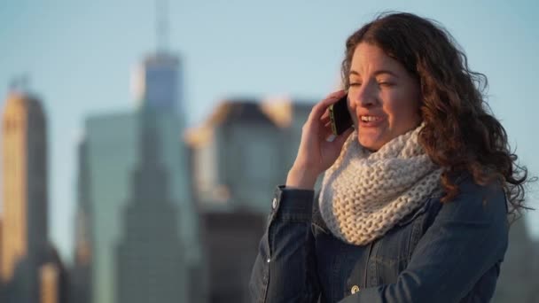 Een mooie vrouw maakt gebruik van haar mobiele telefoon om te bellen en tekst — Stockvideo