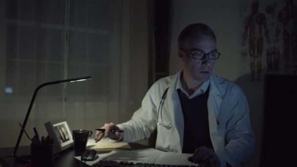 En læge ved hans kontor skrivebord – Stock-video