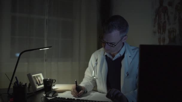 Um médico em sua mesa de escritório — Vídeo de Stock