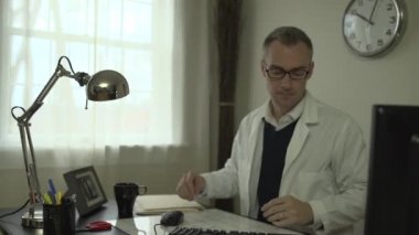 Onun ofis masasında bir tıp doktoru
