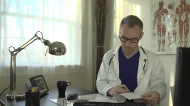 Bir doktor ofis masasında çalışıyor