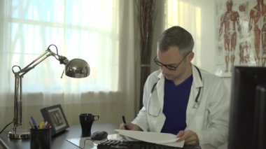 Bir doktor ofis masasında çalışıyor