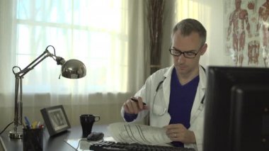 Bir doktor ofis masasında çalışıyor