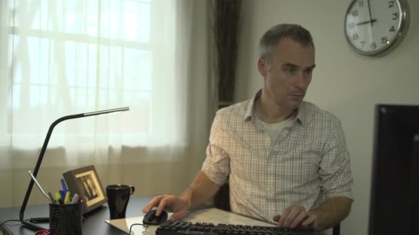 Чоловік працює за чистим столом з комп'ютером і клавіатурою — стокове відео