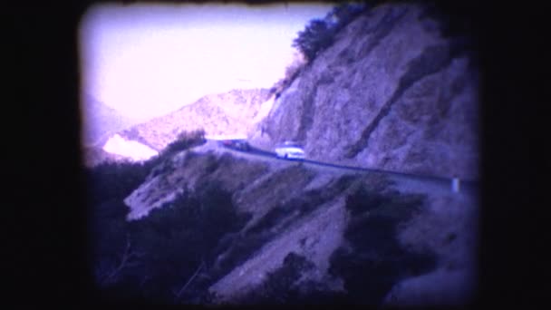 Vintage 8mm footage of cars driving on a mountain pass — Stock Video