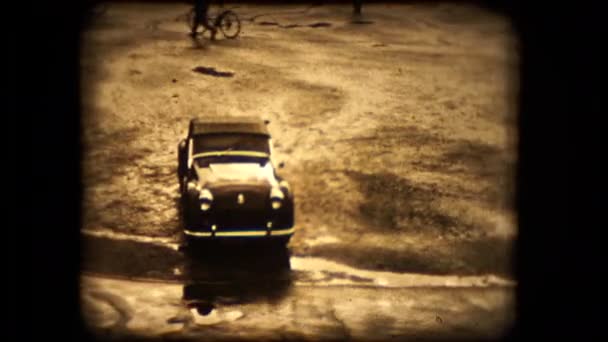 A TR2 Triumph sports car pulls away from the camera on a rainy Paris morning in 1955 — Stock Video