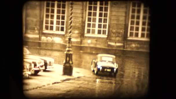 En Triumph Tr2 sportbil drar sig undan från kameran på en regnig morgon Paris 1955 — Stockvideo