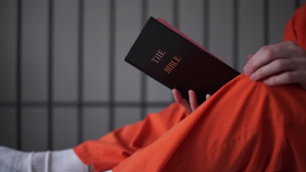 Szene eines Häftlings, der im Gefängnis eine Bibel liest — Stockvideo