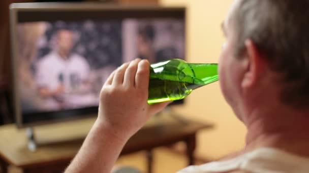 Mann schaut fern und trinkt zu Hause Bier — Stockvideo