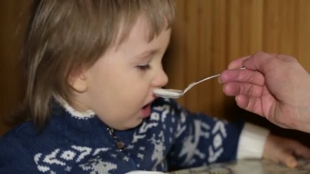 Hand feeding little boy with spoon of yogurt — Stock Video