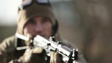 Bir asker silahlı bir Ak-47 ateş etmeye hazırlanıyor