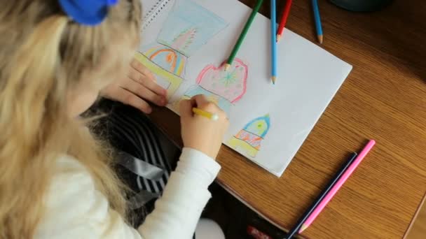 Маленька красива дівчинка малює з кольоровими маркерами за столом в кімнаті . — стокове відео