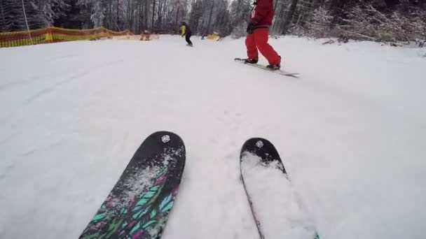 Esquiadores y snowboarders cabalgan en invierno en la ladera nevada — Vídeos de Stock