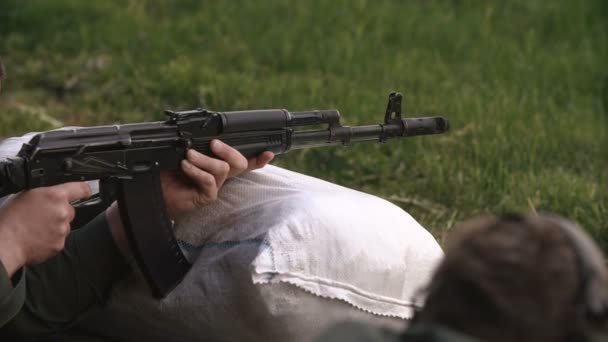 Close-up, soldado disparando uma AK-47 no campo de batalha — Vídeo de Stock