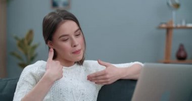 Milenyum kadını dizüstü bilgisayar kullanırken görüntülü konuşma yapıyor. Güzel bir kadın evde otururken işaret diliyle gülümsüyor ve senin için çok mutlu oluyor. İşitme kaybı.