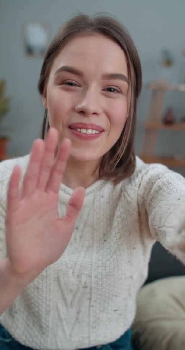 Crop view of joyful woman having video conversation on smartphone while sitting on sofa. Belle femme souriante et disant en langage des signes Bonjour, comment allez-vous Vidéo verticale. — Video