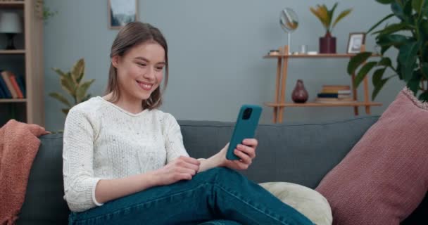 ビデオ会話や手話のフレーズで示す魅力的な若い聴覚障害者の女性あなたのために幸せです。女性の笑顔とコミュニケーションのためのスマートフォンを使用しています。難聴. — ストック動画