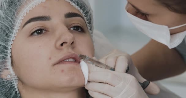 Augmentarea buzelor. Medicul cosmetolog face procedura de augmentare a buzelor unei femei frumoase într-un salon de înfrumusețare. Conceptul de injecție cosmetică de frumusețe — Videoclip de stoc