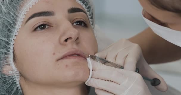 Lip Augmentation. The doctor cosmetologist makes lip augmentation procedure of a beautiful woman in a beauty salon. Cosmetic beauty injection concept — Stock Video