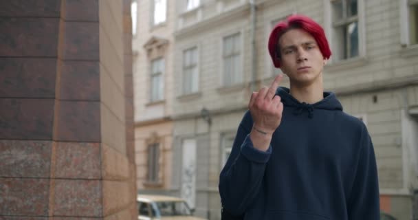 Jeune hipster aux cheveux roux teints montrant le majeur debout dans la rue. Homme millénaire démontrant haine et impolitesse geste grossier de manque de respect tout en regardant à la caméra. — Video