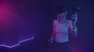 Sanal gerçeklik kulaklığı takan, elinde Joystick Kontrolörleri Davulda çalan, Soyut Sinir Işığı Arkaplanına Heyecanlı Bakan Genç Mutlu Kız. VR, Eğlence Konsepti.