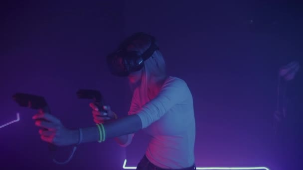 Lány Gamer Viselő Virtuális Valóság Fejhallgató Holding Joystick Controllers Játék Akció, Holding géppisztoly Neon Lighting Háttér. VR, szórakoztató koncepció. — Stock videók