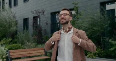 Şehir caddesinde yürürken gözlüklü ve atkılı neşeli bir adam şarkı söylüyor ve dans ediyor. Havalı sakallı adam takım elbisesini ayarlıyor ve dışarıda havası yerindeyken ritmi tutturuyor..